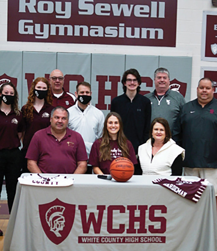 Morgan Quick is surrounded by her parents, friends, coaches, and school personnel as she signs with Freed-Hardeman University.